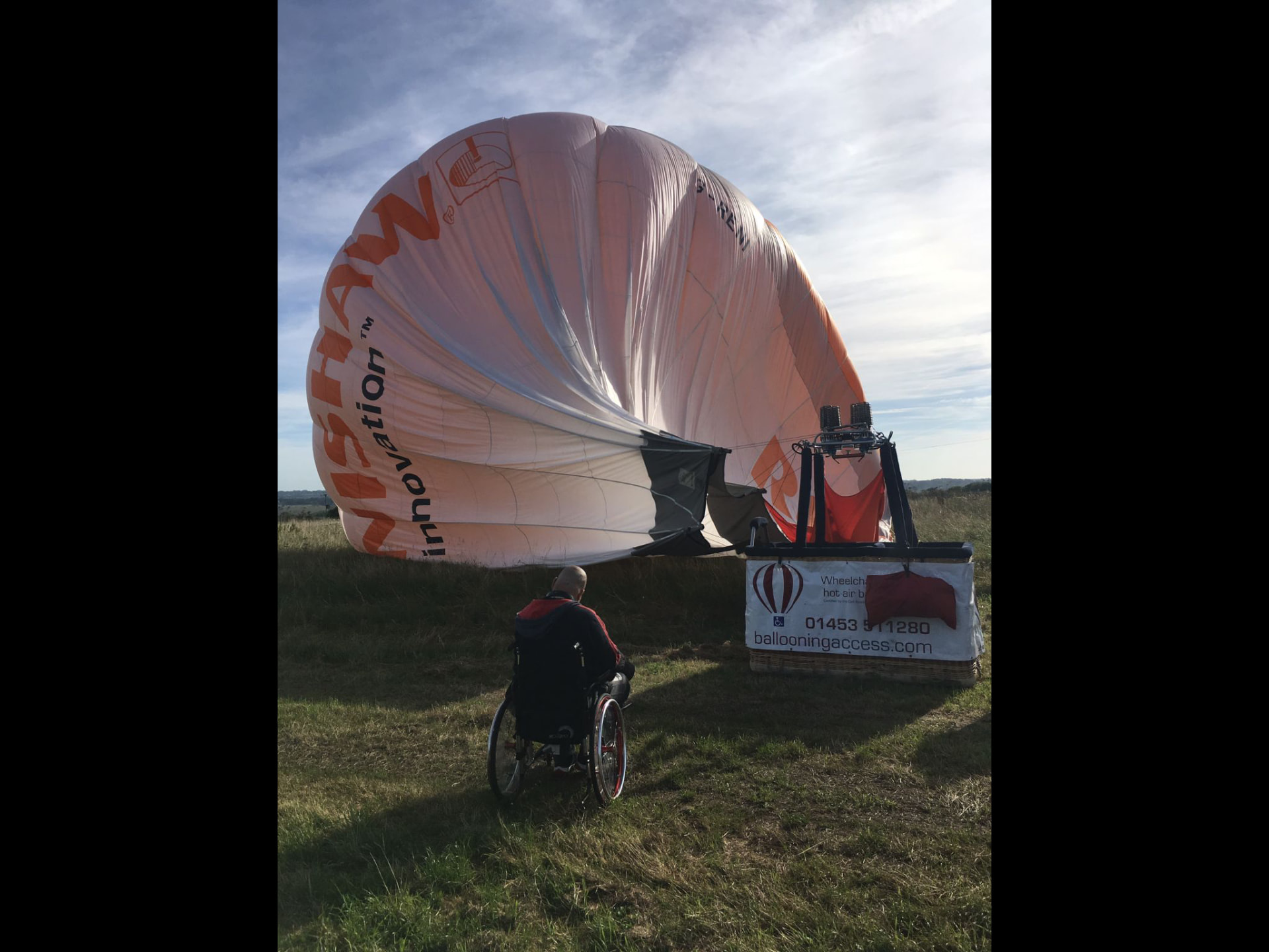Chris beside a wheelchair-accessible hot-air balloon being inflated