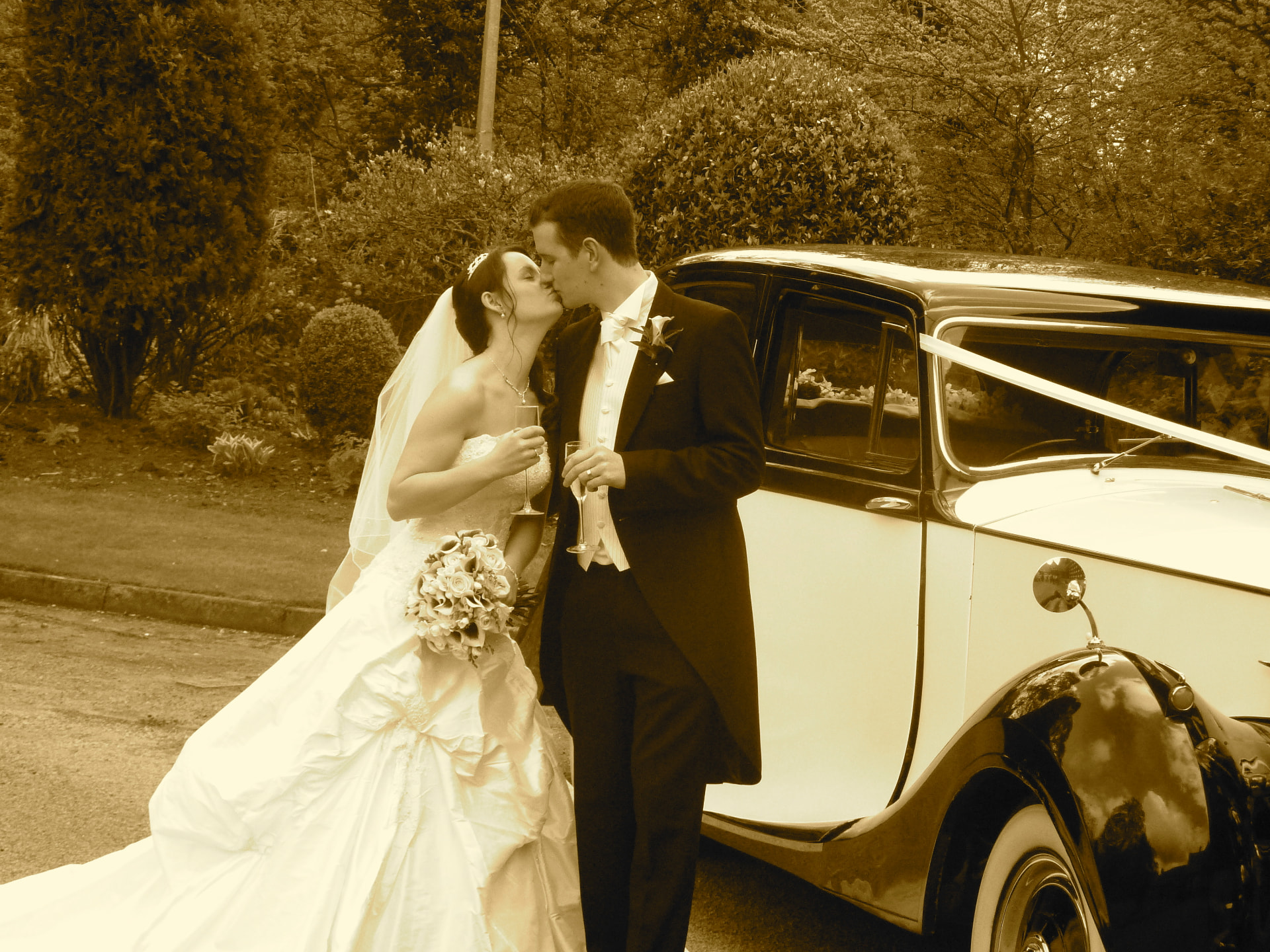 My niece and her new husband celebrating their wedding beside a beautiful classic car.
